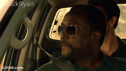 A Man Wearing Sunglasses Is Sitting In A Car With The Name Jack Ryan On The Bottom GIF