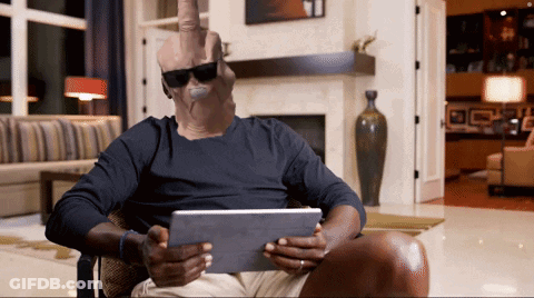 A Man Wearing Sunglasses Is Sitting In A Chair Holding A Tablet GIF