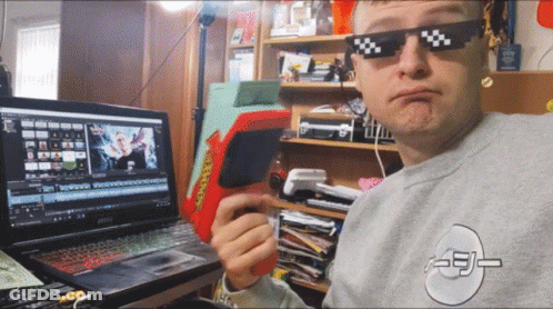 A Man Wearing Sunglasses Is Sitting In Front Of A Msi Laptop Computer GIF