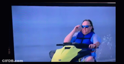 A Man Wearing Sunglasses Is Sitting On A Jet Ski GIF