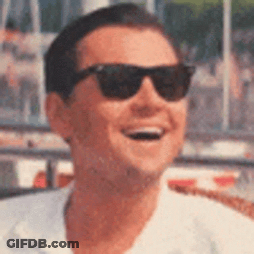 A Man Wearing Sunglasses Is Smiling In A Close Up Of His Face . GIF