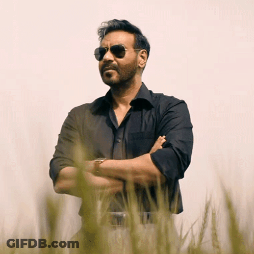 A Man Wearing Sunglasses Is Standing In A Field Of Tall Grass GIF
