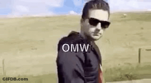 A Man Wearing Sunglasses Is Standing In A Field With The Word Omw Written On The Screen . GIF