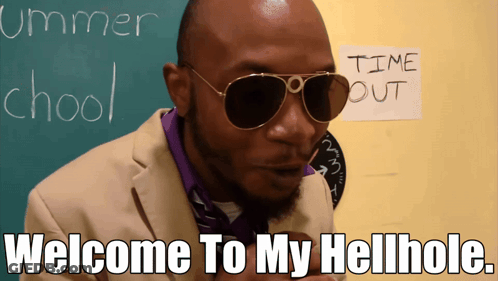 A Man Wearing Sunglasses Is Standing In Front Of A Chalkboard That Says Summer School GIF