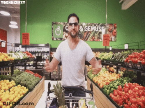 A Man Wearing Sunglasses Is Standing In Front Of A Sign That Says " C & Gemuse " GIF