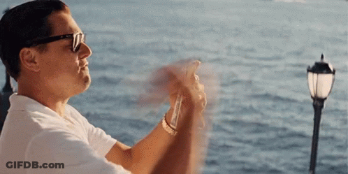 A Man Wearing Sunglasses Is Taking A Picture Of The Ocean GIF