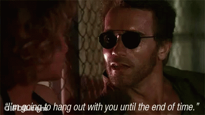 A Man Wearing Sunglasses Is Talking To A Woman Who Is Holding His Neck GIF