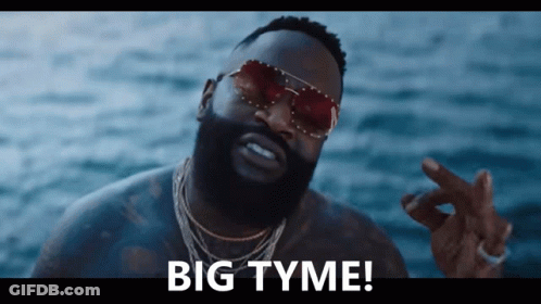 A Man Wearing Sunglasses Says " Big Tyme " In Front Of The Ocean GIF