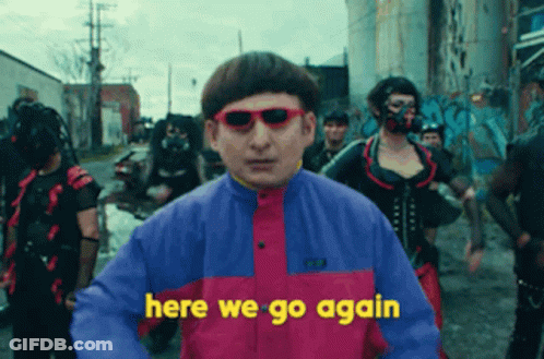 A Man Wearing Sunglasses Says Here We Go Again In Front Of A Crowd Of People GIF