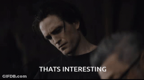A Man Wearing Sunglasses Says Thats Interesting In A Dark Room GIF