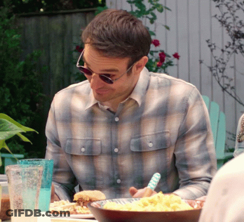 A Man Wearing Sunglasses Sits At A Table With Food GIF