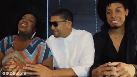 A Man Wearing Sunglasses Sits Next To A Woman In A Striped Shirt GIF