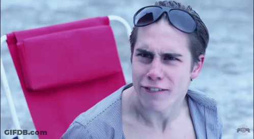 A Man Wearing Sunglasses Sitting In A Red Chair GIF