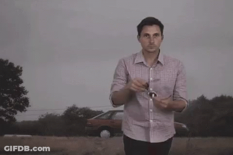A Man Wearing Sunglasses Stands In Front Of A Large Explosion GIF