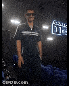 A Man Wearing Sunglasses Stands In Front Of A Sign That Says Avals GIF