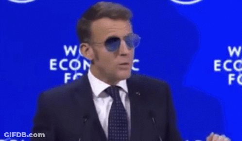 A Man Wearing Sunglasses Stands In Front Of A Sign That Says " For Sure " GIF