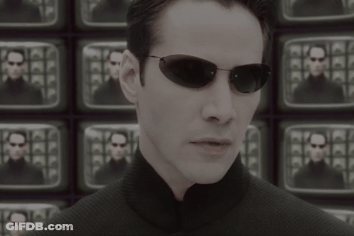 A Man Wearing Sunglasses Stands In Front Of A Wall Of Televisions With The Words The Problem Is Choice Below Him GIF