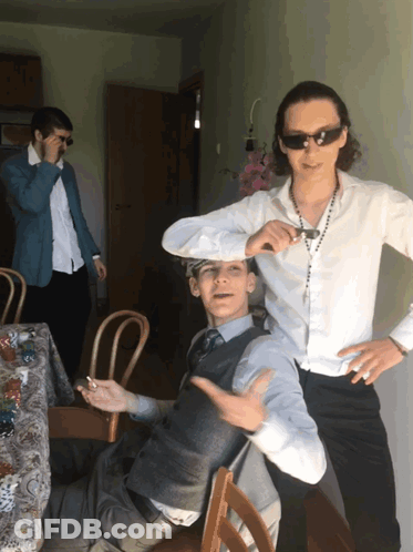 A Man Wearing Sunglasses Stands Next To Another Man GIF