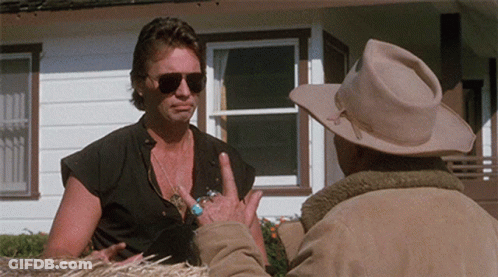 A Man Wearing Sunglasses Talks To Another Man In A Cowboy Hat GIF