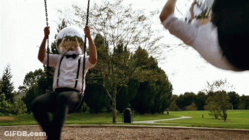 A Man Wearing Suspenders And A Helmet Swings On A Swing GIF