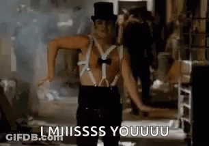 A Man Wearing Suspenders And A Top Hat Is Dancing In A Room . GIF