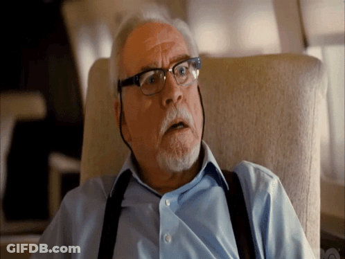 A Man Wearing Suspenders And Glasses Looks Surprised GIF