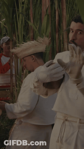 A Man Wearing White Gloves And A Straw Hat Is Playing A Musical Instrument GIF