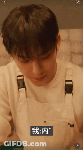 A Man Wearing White Overalls With Chinese Writing On The Bottom Right GIF