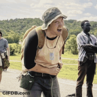 A Man With A Backpack Is Laughing While Another Man Looks On GIF