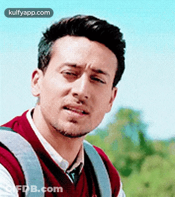 A Man With A Backpack Is Making A Funny Face While Looking At The Camera . GIF