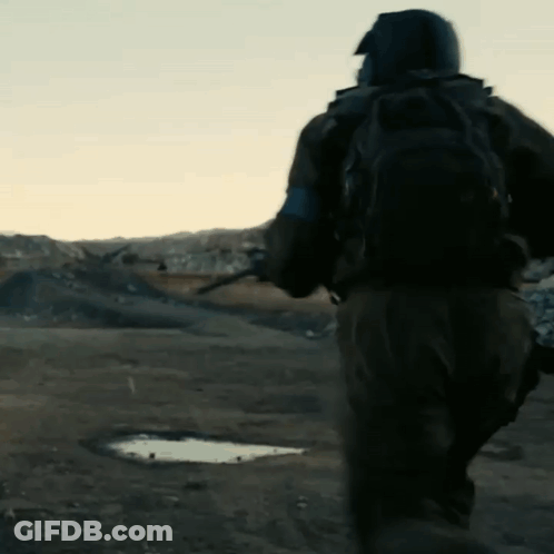 A Man With A Backpack Is Running In The Desert GIF