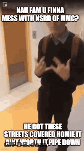 A Man With A Backpack Is Standing In A Hallway And Making A Funny Face GIF