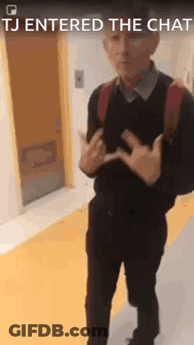 A Man With A Backpack Is Standing In A Hallway With The Words Tj Entered The Chat Above Him . GIF