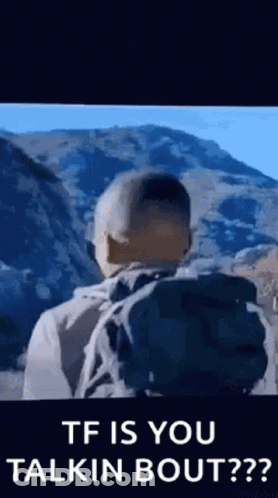 Man With Backpack Standing In Front Of Mountain Talking GIF
