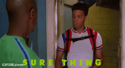 A Man With A Backpack Is Standing Next To Another Man With The Word Sure Thing Written On The Wall Behind Him GIF