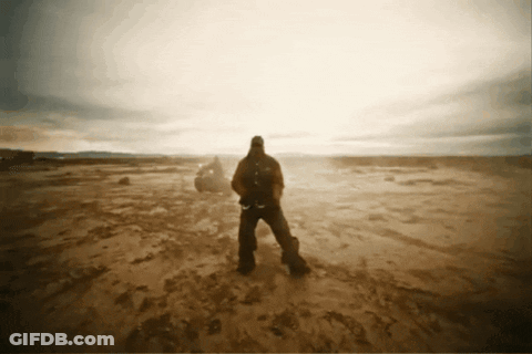 A Man With A Backpack Stands In A Desert GIF