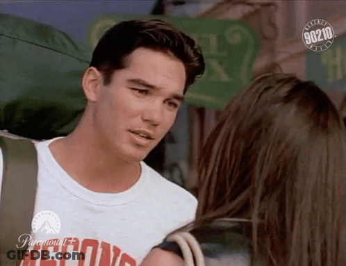 A Man With A Backpack Talks To A Woman With A 90210 Logo In The Corner GIF