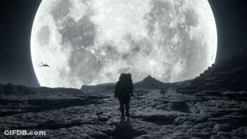 A Man With A Backpack Walking In Front Of A Large Full Moon GIF