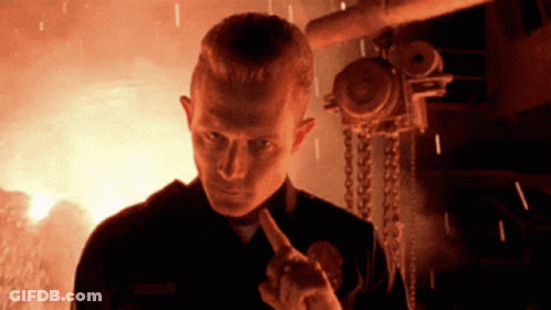 A Man With A Badge That Says ' Smith ' On It Stands In Front Of A Fire GIF