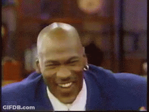 A Man With A Bald Head Is Smiling And Wearing Earrings GIF
