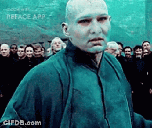 A Man With A Bald Head Is Standing In Front Of A Crowd Of People . GIF
