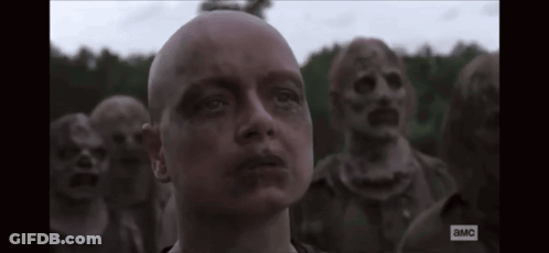 A Man With A Bald Head Is Standing In Front Of A Group Of Zombies With The Letters A And Mc On The Bottom GIF