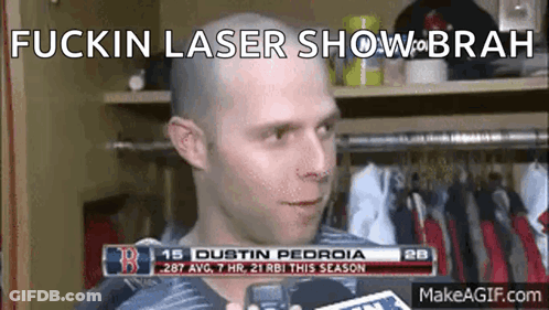 A Man With A Bald Head Is Talking To A Reporter In A Locker Room With The Words Fuckin Laser Show On The Bottom GIF
