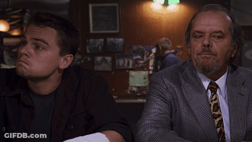 A Man With A Bandage On His Arm Sits Next To A Man In A Suit And Tie GIF