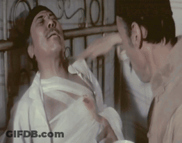 A Man With A Bandage On His Chest Is Being Hit By Another Man GIF