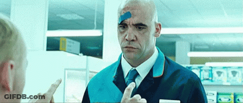 A Man With A Bandage On His Head Is Talking To Another Man In A Store . GIF