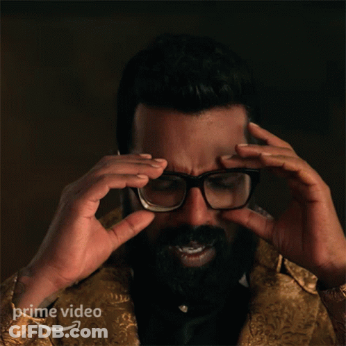 A Man With A Beard Adjusts His Glasses With A Prime Video Logo In The Corner GIF
