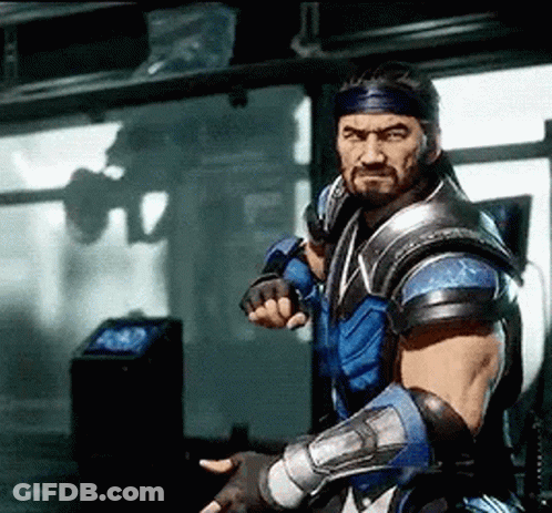 A Man With A Beard And A Bandana On His Head Is Standing In A Room Holding A Sword . GIF