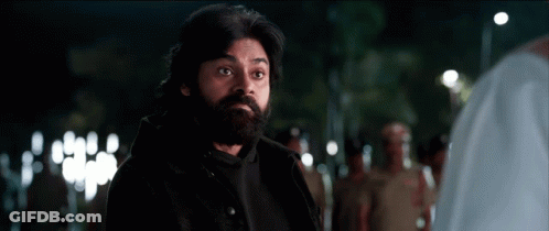 A Man With A Beard And A Black Jacket Is Standing In A Crowd Of People . GIF