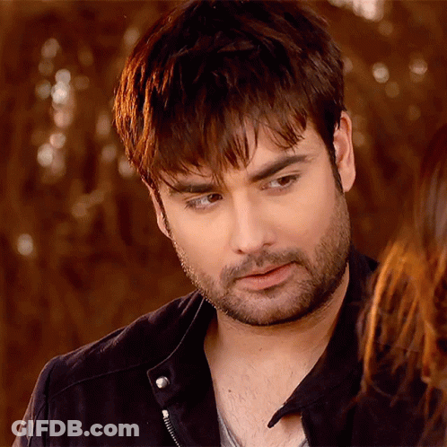 A Man With A Beard And A Black Jacket Looks At The Camera GIF